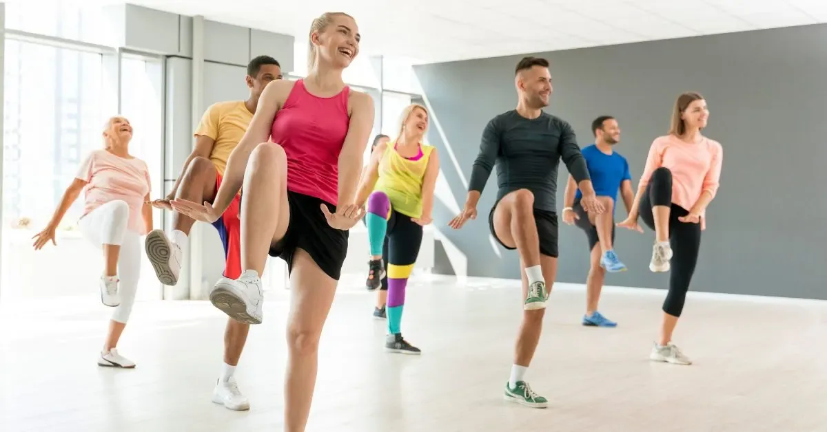 Energetic group dancing and smiling during a Zumba fitness class in Madurai.